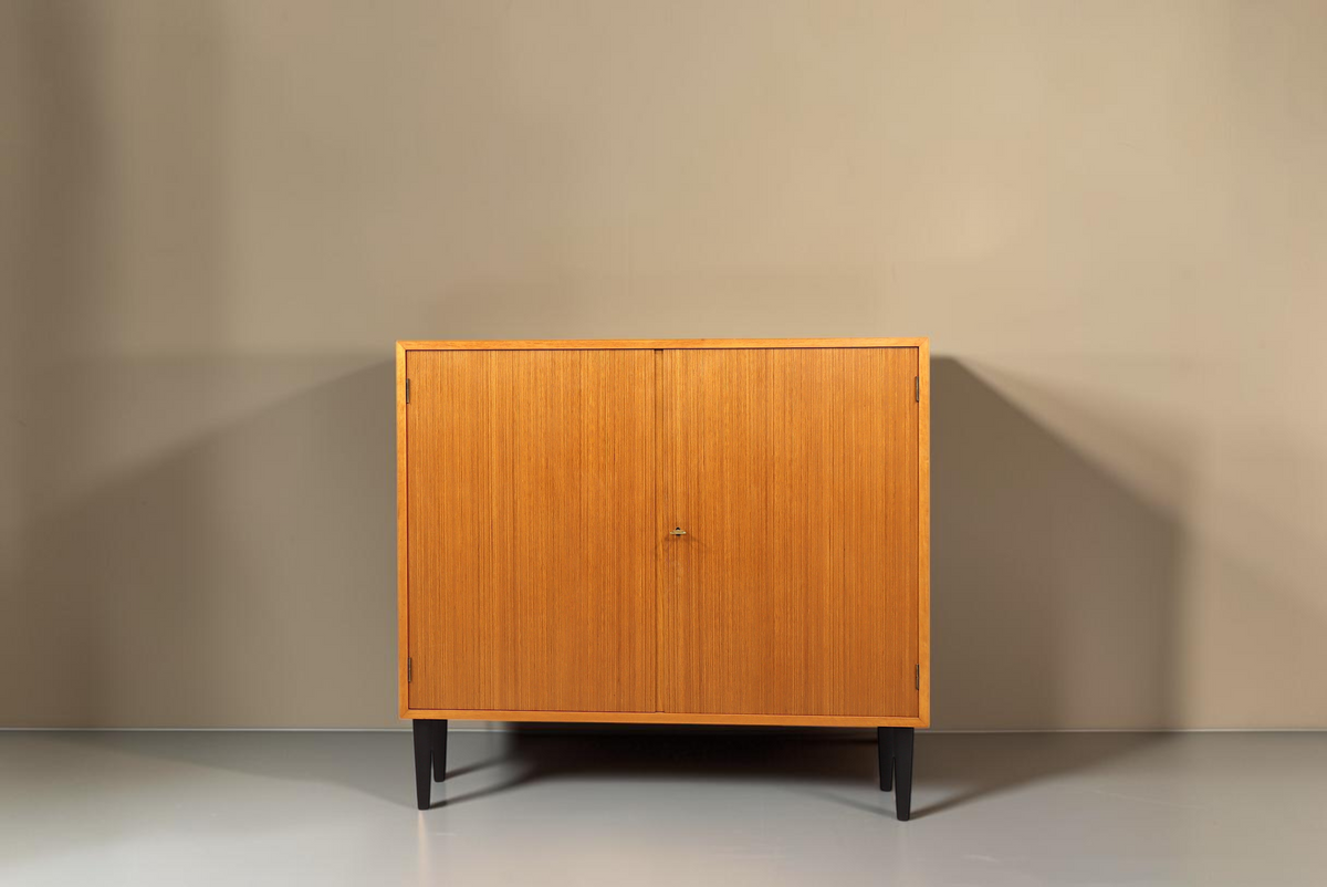 Vintage Space Mid Century Schrank aus Holz mit zwei Türen und schwarzen konischen Füßen vor weißem Hintergrund