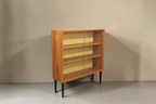 Vintage Space Hellerau Mid Century Vitrine aus Holz mit Glasschiebetüren und senfgelber Rückwand auf schwarzen Beinen