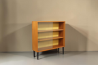 Vintage Space Hellerau Mid Century Vitrine mit Glasschiebetüren, Holzfurnier und gelber Rückwand auf schwarzen Beinen