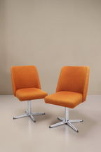 Zwei Vintage Space orangefarbene Mid-Century Drehstühle mit Aluminium-Sternfuß vor weißem Hintergrund