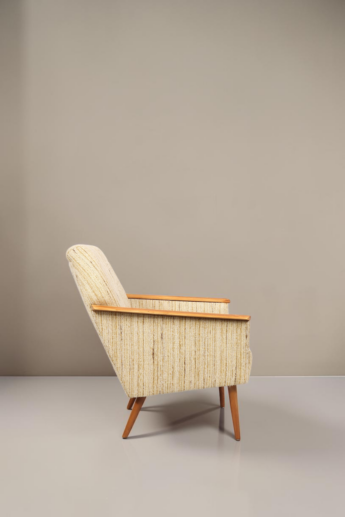 Vintage Space Mid Century Lounge Sessel mit hellem Strukturstoff, Holzarmlehnen und konischen Beinen in Seitenansicht