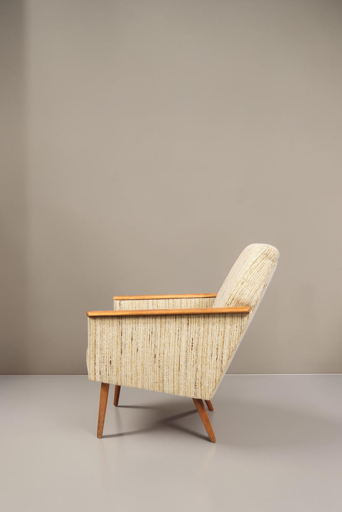 Vintage Space Mid Century Lounge Sessel mit hellem Strukturstoff, Holzarmlehnen und konischen Holzbeinen in Seitenansicht