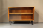 Vintage Space Mid Century Vitrine aus Holz mit Glasschiebetüren und schwarzen konischen Füßen vor weißem Hintergrund