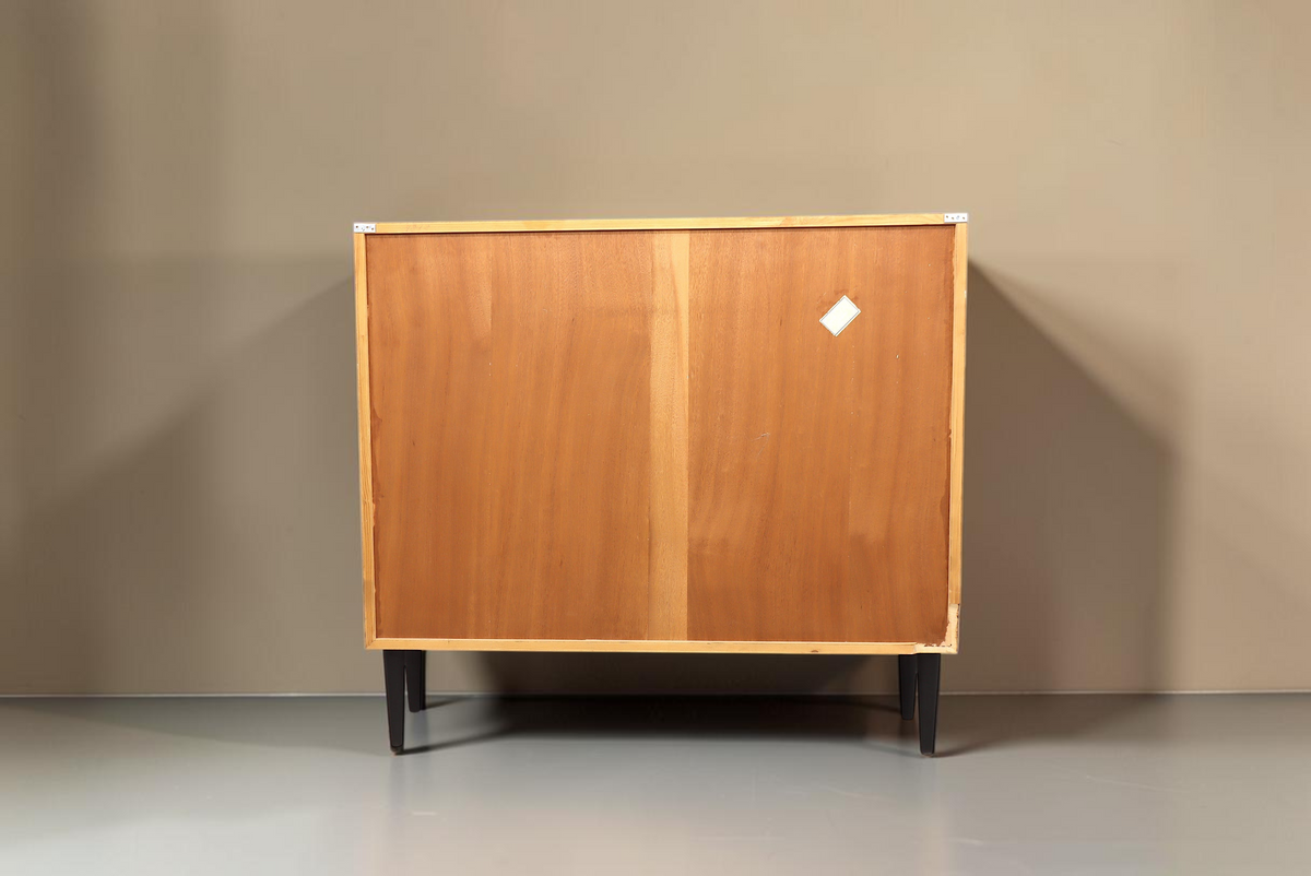 Rückansicht des Vintage Space Mid Century Schranks aus Holz mit schwarzen konischen Füßen vor weißem Hintergrund