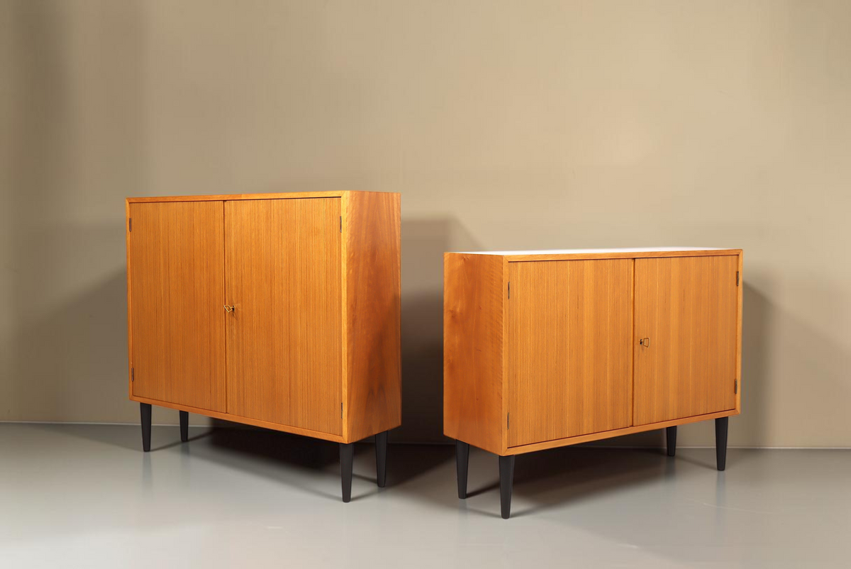 Zwei Vintage Space Mid Century Kommoden aus Holz mit schwarzen konischen Füßen und zwei Türen vor weißem Hintergrund