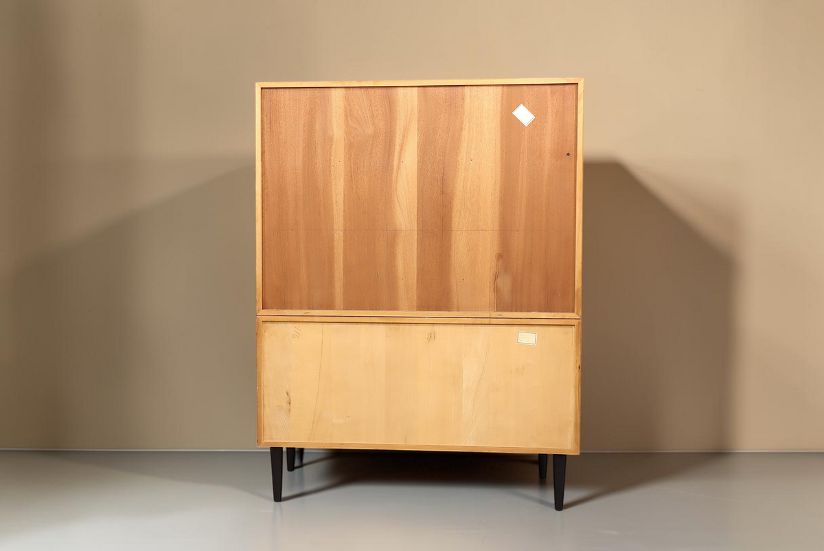Rückansicht des Vintage Space Mid Century Sekretärs aus hellem Holz mit schwarzen konischen Füßen