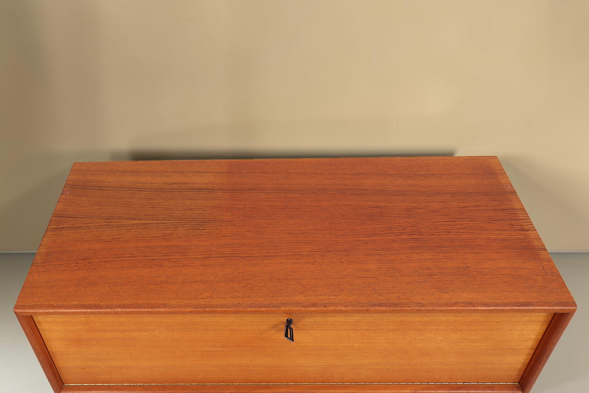 Vintage Space Mid Century Teak Kommode mit abschließbarer Klapptür und markanter Holzmaserung in der Draufsicht