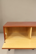 Vintage Space Mid Century Teak Sideboard mit offener Klapptür und hellem Innenraum vor weißer Wand